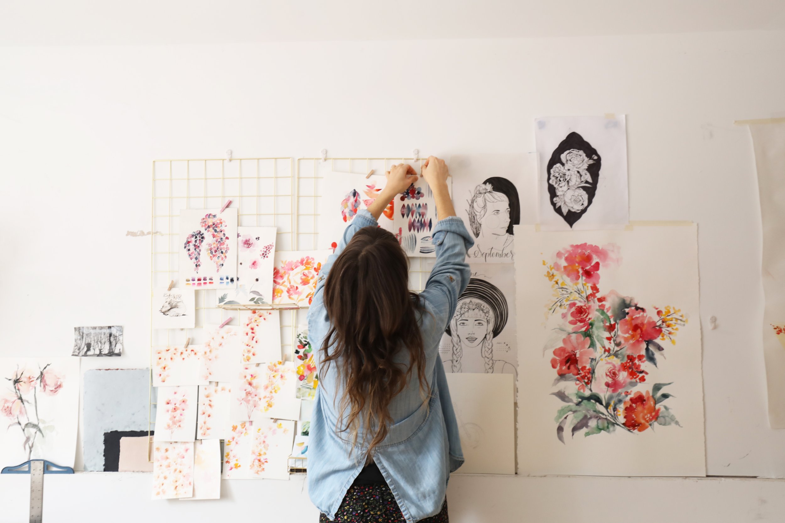 Watercolor Artist Jaime Reynolds pins her original artwork on her studio wall